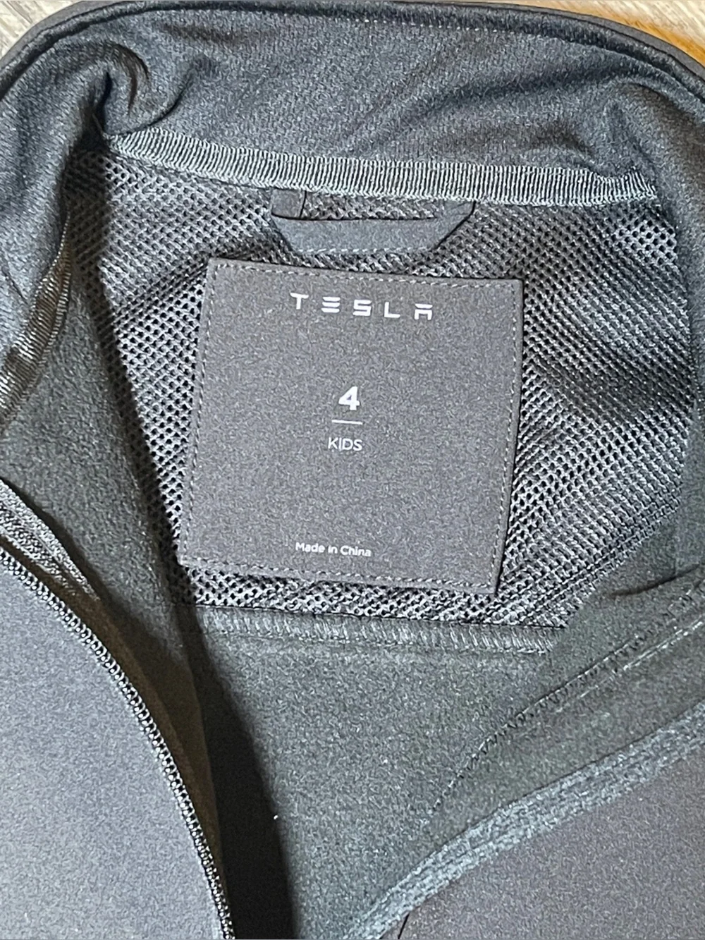 TESLA -The image features a Tesla Kids Corporate Softshell Jacket, black